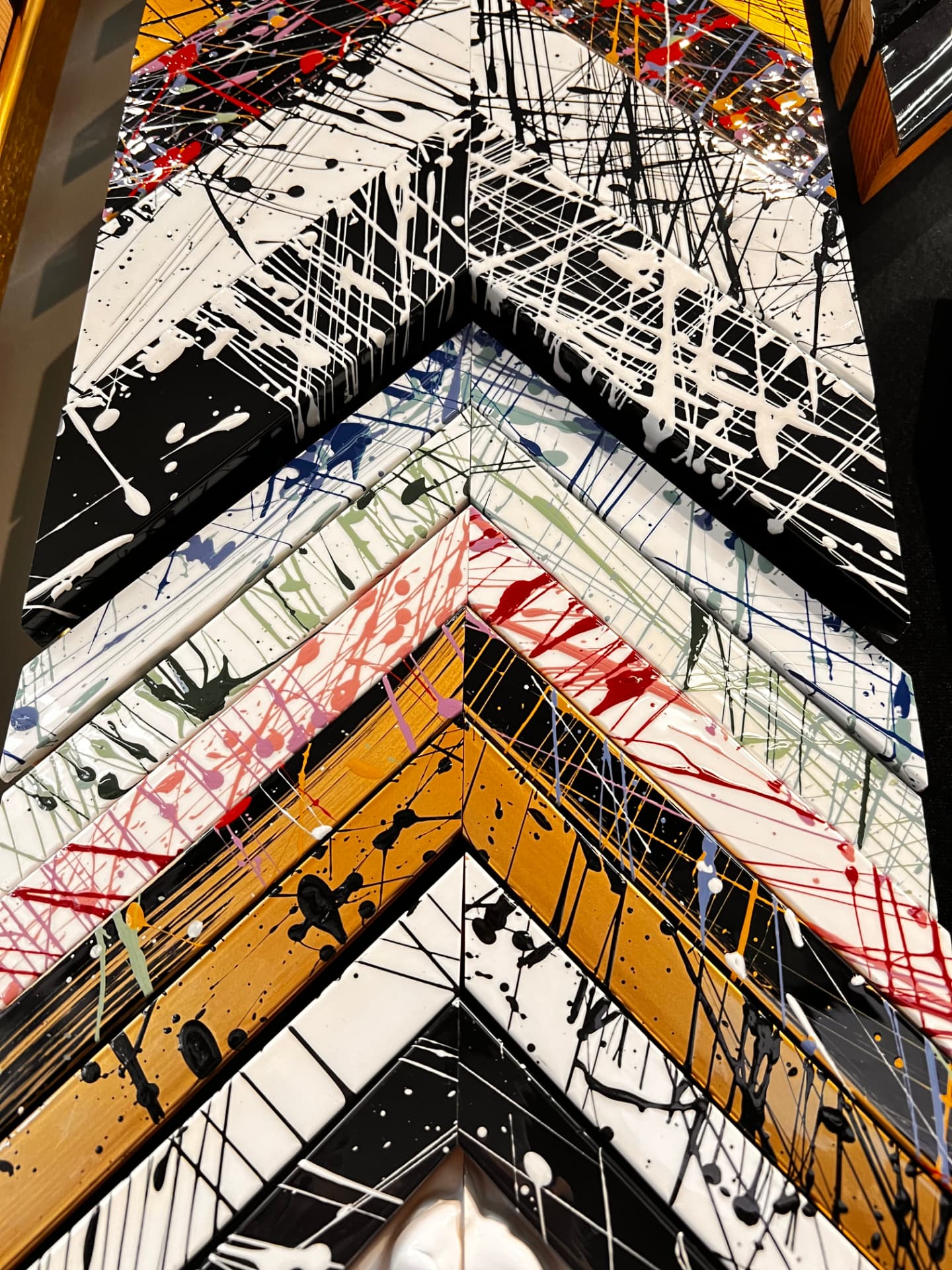 Corner samples of paint-splatter frame mouldings in black, white, gold, and bright colors